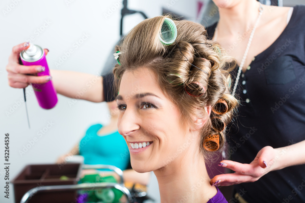 Fototapeta premium Hairdresser - hair stylist curling hairs