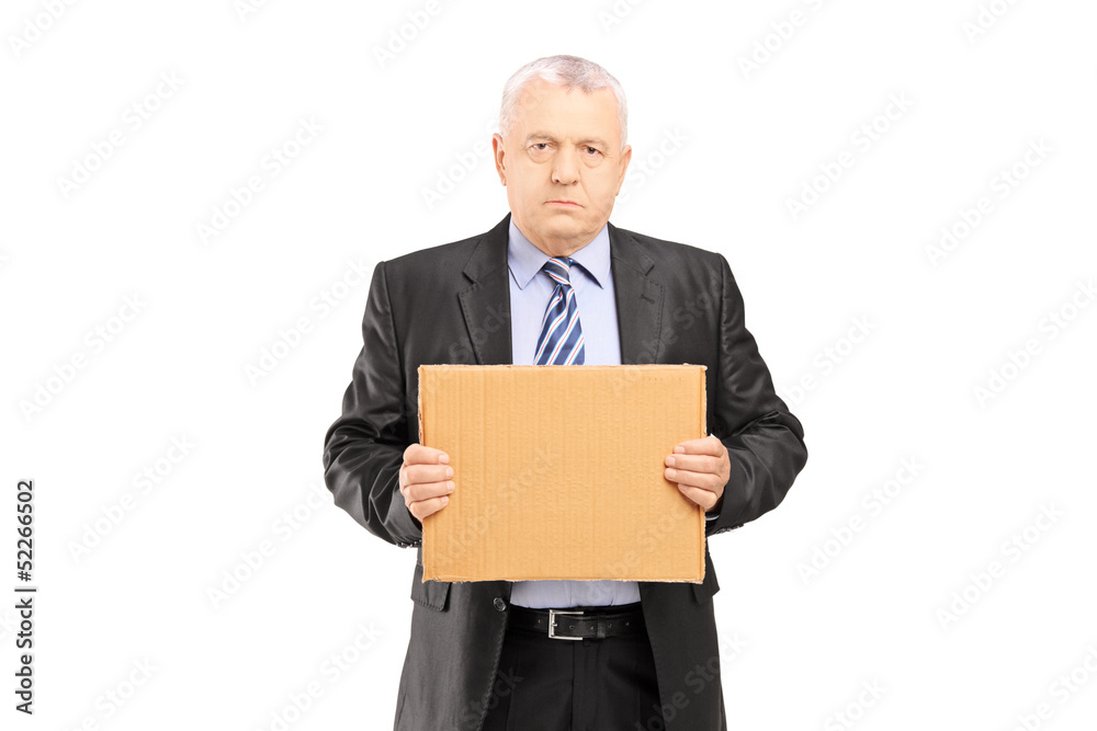Sad middle aged businessman holding a piece of cardboard and loo Sad middle aged businessman holding a piece of cardboard and loo