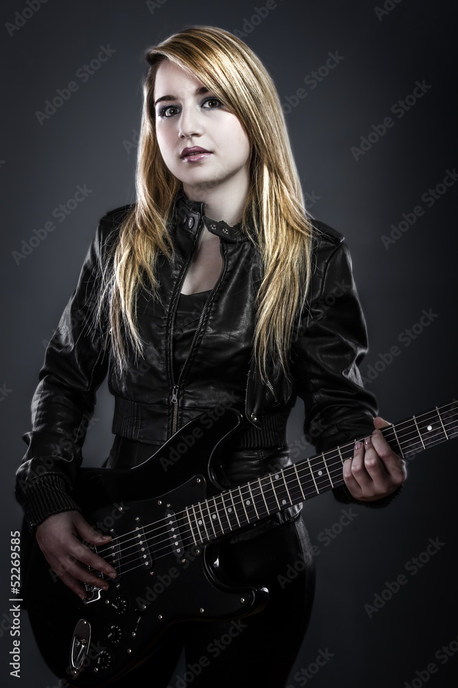 Teenager holding a black electric guitar