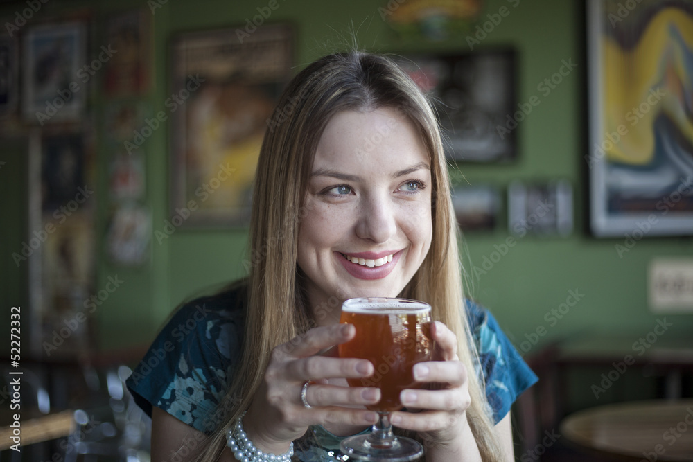Blonde Woman with Beautiful Blue Eyes Drinks a Goblet of Beer