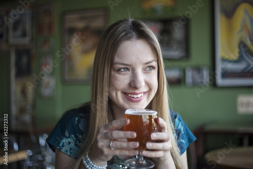 Obraz na płótnie Blonde Woman with Beautiful Blue Eyes Drinks a Goblet of Beer w salonie