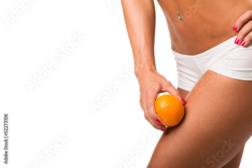 A young girl in underwear with an orange on a white background