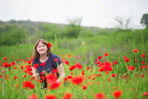 Smiling girl in a beautiful poppy meadow