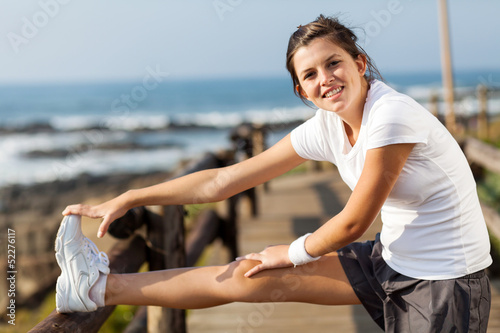 fit teen girl exercising at beach