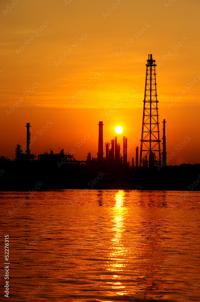 Silhouette oil refinery at sunrise