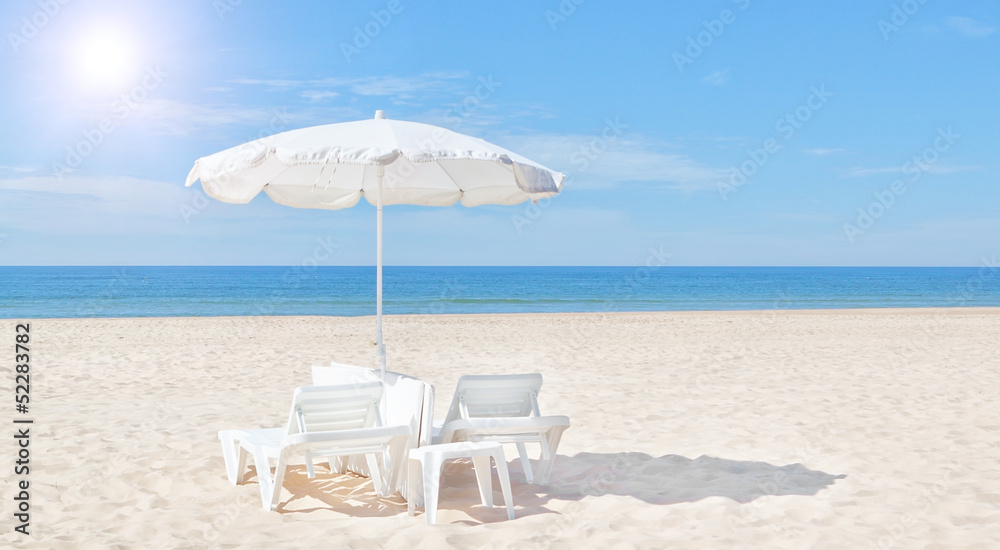Beautiful white beach umbrella and sun bed on the beach. For the