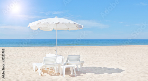 Beautiful white beach umbrella and sun bed on the beach. For the