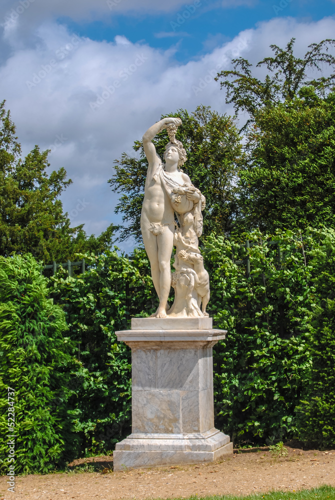 statue of Bacchus with grape in the Gardens of Versailles, Franc