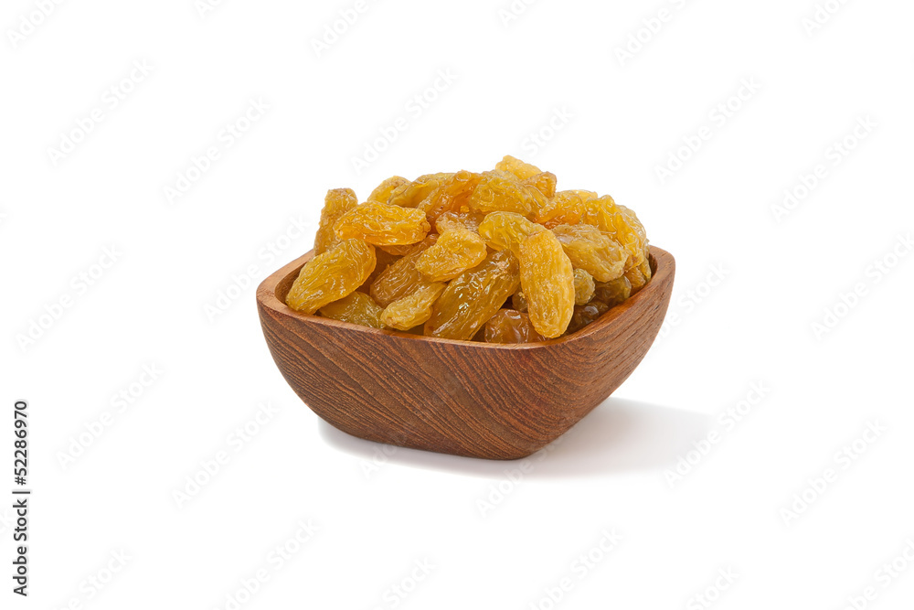 Yellow raisins in a wooden Pialat on white background Yellow raisins in a wooden Pialat on white background