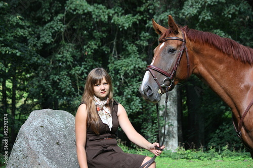 Beautiful teenage girl resting on the rock in park and horse sta © virgonira