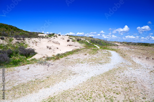 path in sand dunes over blue sky