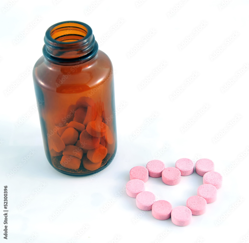 Heart shape pills with a bottle on white background Heart shape pills with a bottle on white background