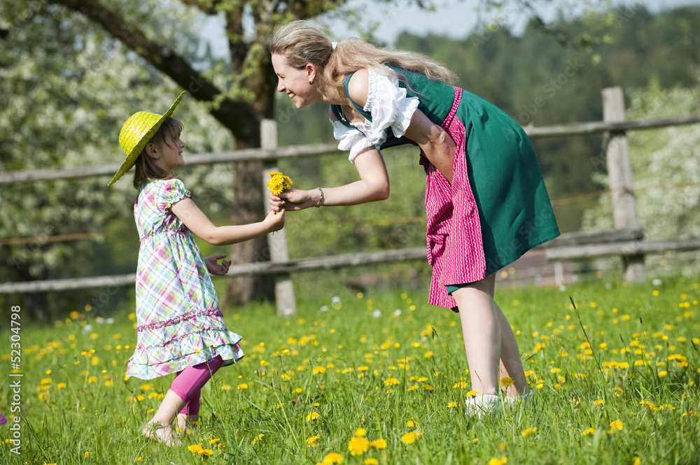 Fototapeta premium Mädchen bringt Mutter Blumen
