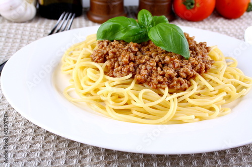 Delicious spaghetti bolognese with basil on white plate
