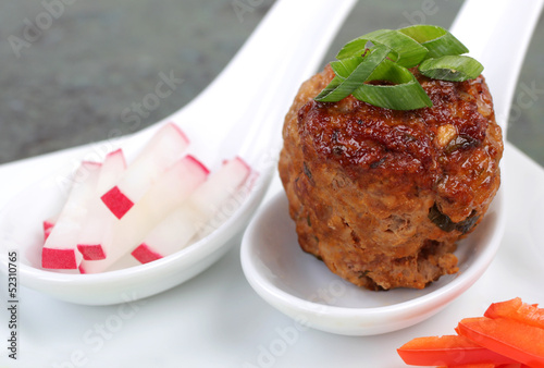 Single Asian meatball with condiments.