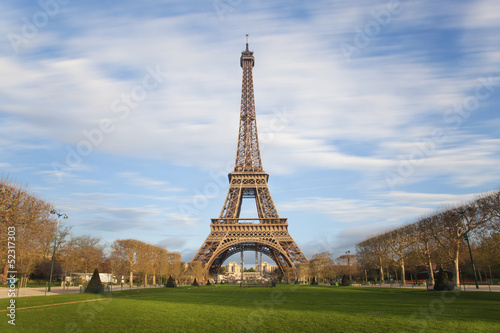 Eiffel tower with moving clouds on blue sky, Paris