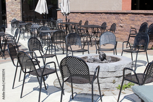 Outdoor restaturant with tables and chairs around fire pit
