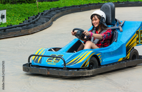 Cute Thai girl is driving Go-kart in an amusement park