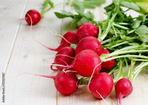 Fresh radishes from ground on old wooden table