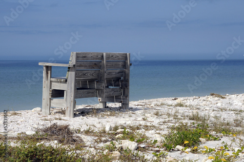 Wooden seat on the beach overlooking the sea © petert2