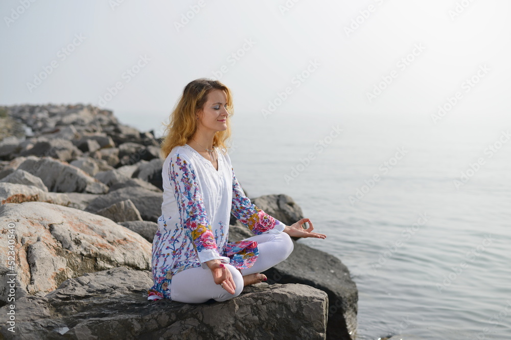 Meditation, Woman on rocky beach in yoga pose