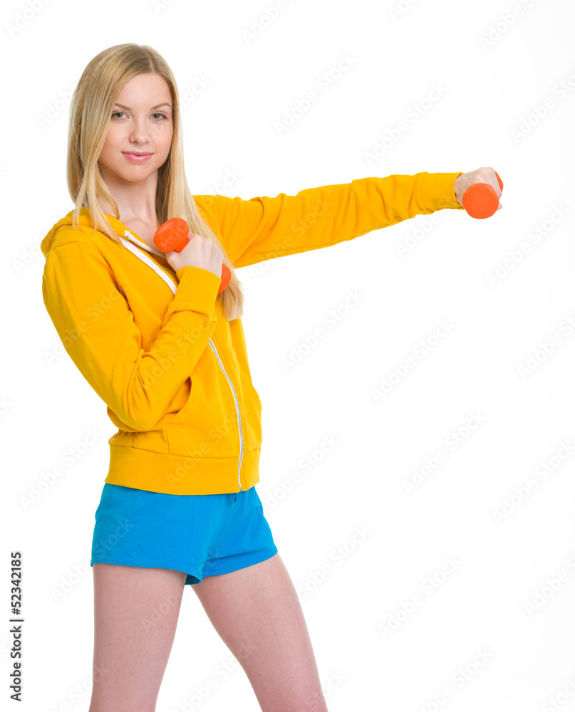 Happy teenager girl making exercise with dumbbells Happy teenager girl making exercise with dumbbells