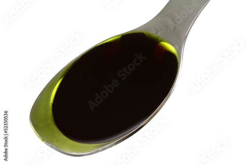 A Spoon filled with Pumpkin Seed Oil, isolated on white photo