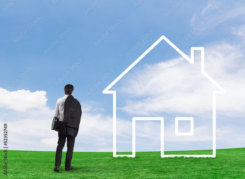 Man drawing a house in a field Man drawing a house in a field