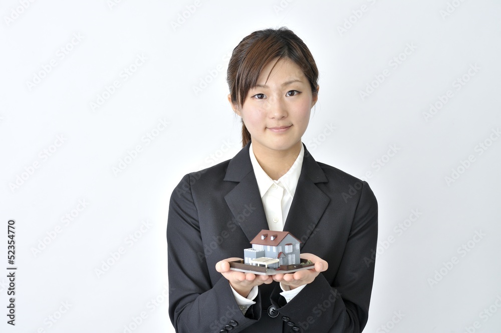 住宅模型を持つ女性