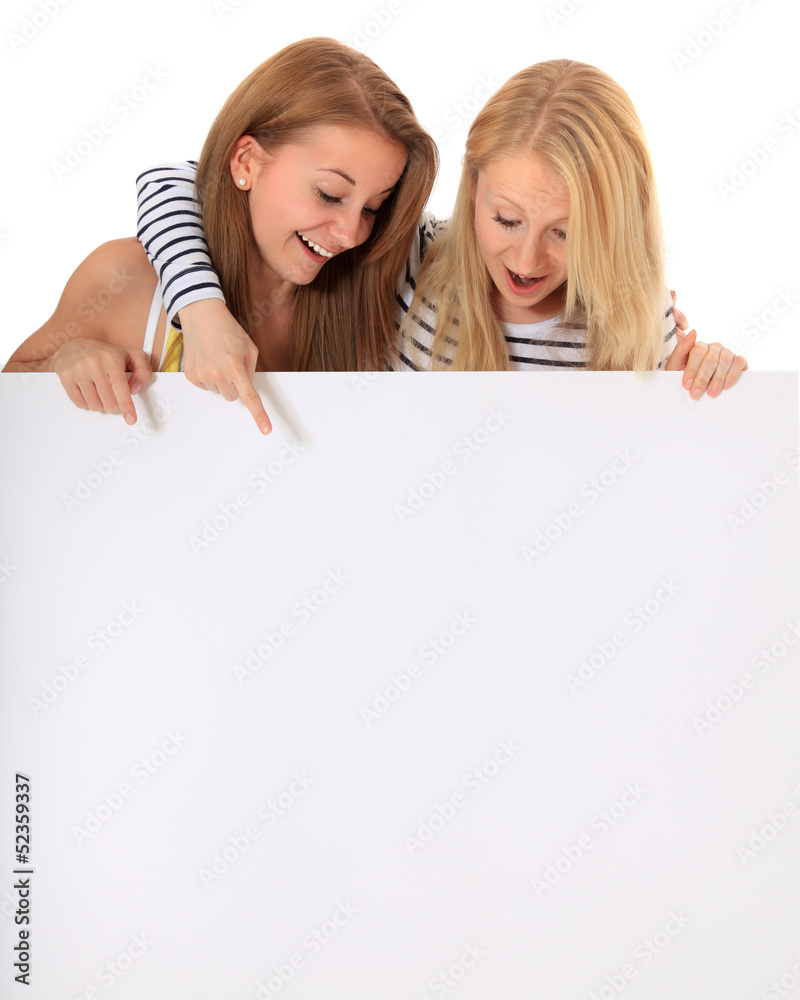 Zwei Teenager bestaunen weißes Schild Zwei Teenager bestaunen weißes Schild