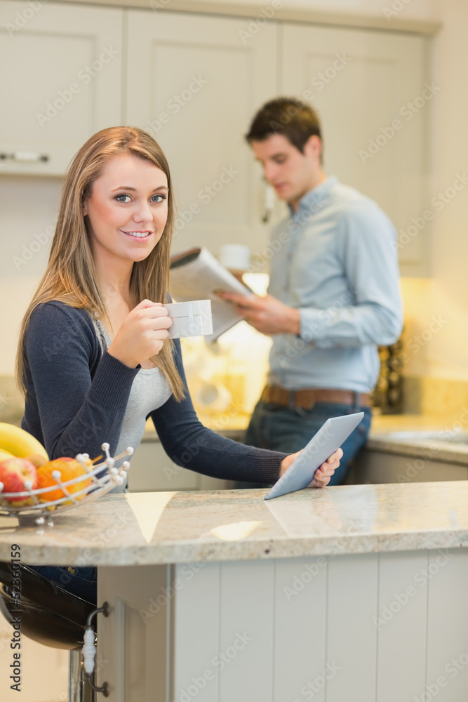 Woman drinking coffee and holding tablet pc