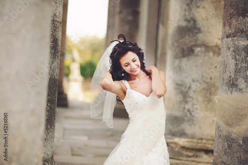 happy caucasian bride between columnes of castle photo