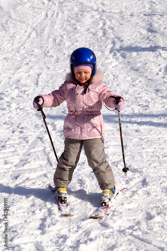 A happy little girl off skiing with slides