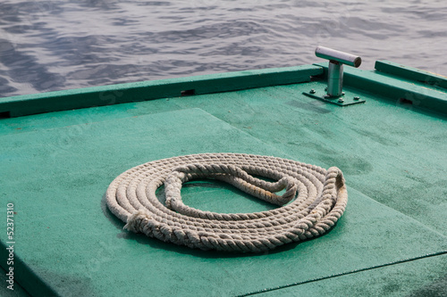 The rope coiled on the green floor of the boat