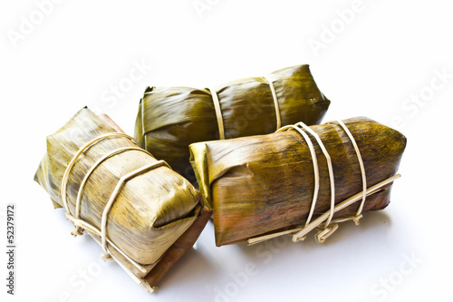Sweets wrapped in banana leaves on a white background