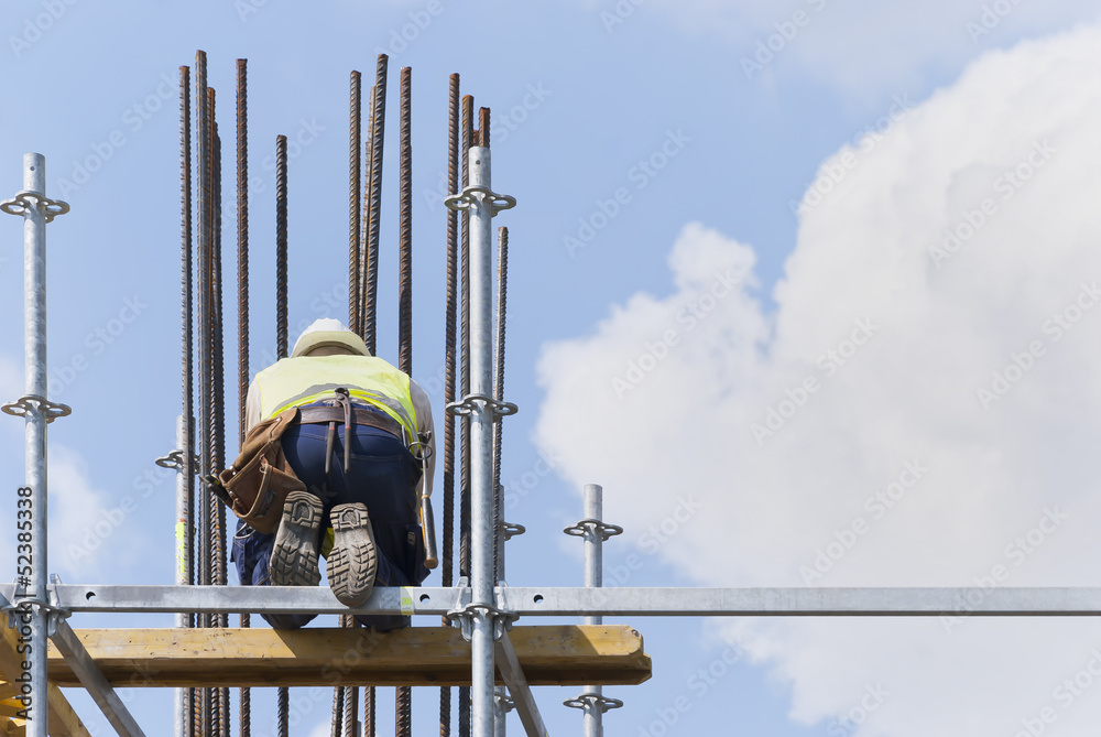 A construction worker on a high wall