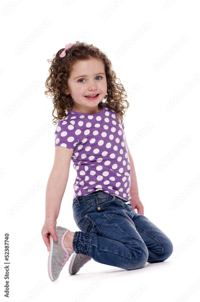 Young child knelt smiling at the camera Young child knelt smiling at the camera