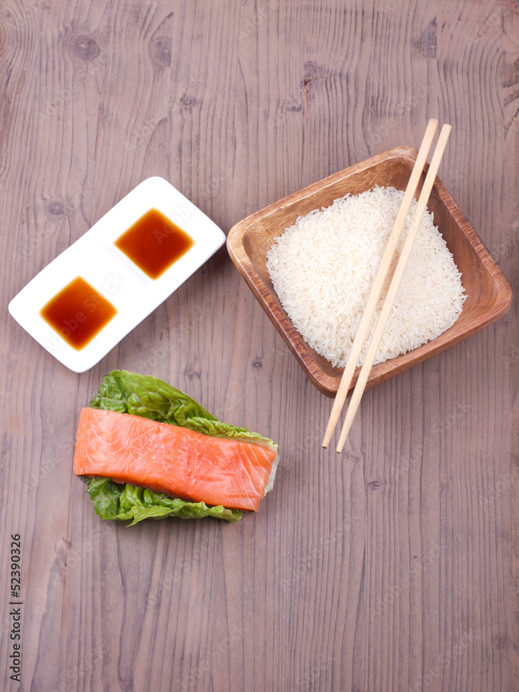 Salmon with rice, sauce and chopsticks