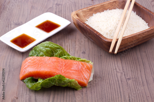 Salmon with rice, sauce and chopsticks