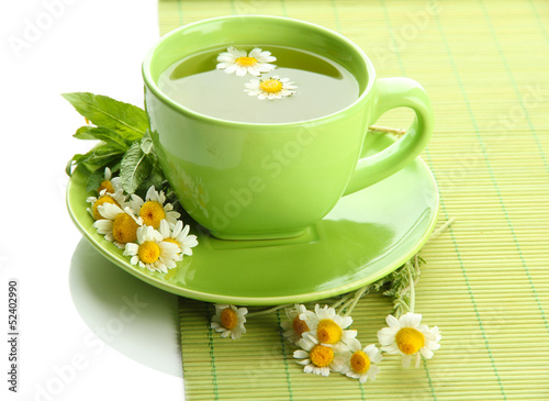 Cup of herbal tea with wild camomiles and mint  isolated