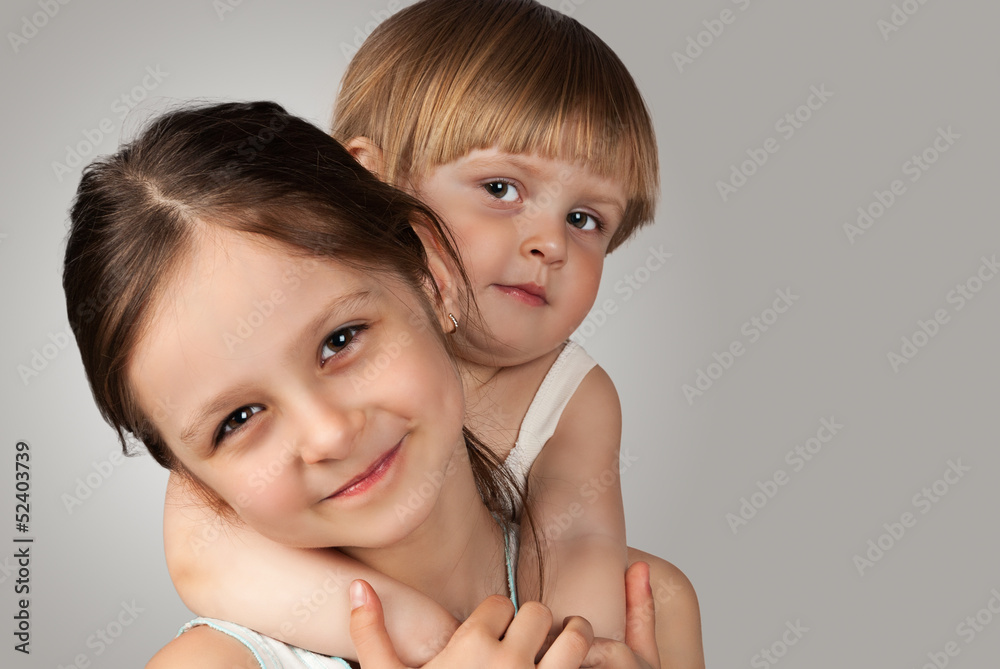 Portrait of two young sisters who embrace