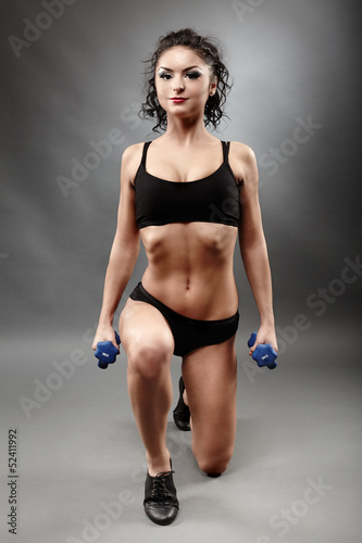 Beautiful sporty woman lifting dumbbells