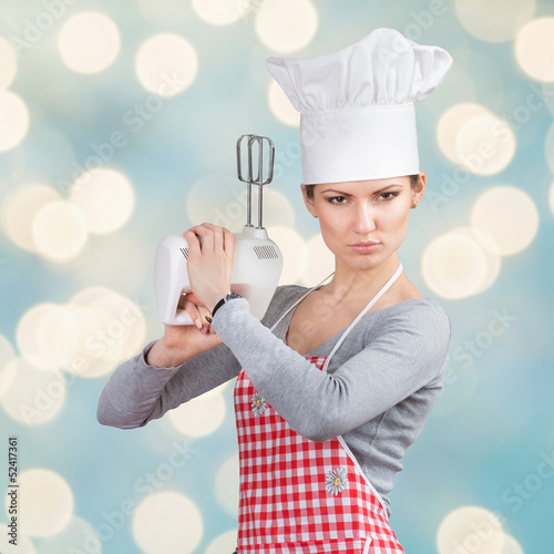 Woman in chef's hat “firing a gun” with the mixer photo