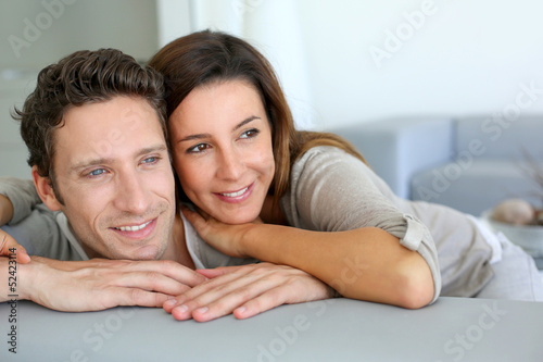 Portrait of sweet couple sitting in sofa © goodluz