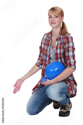 Female artisan kneeling and gesturing photo