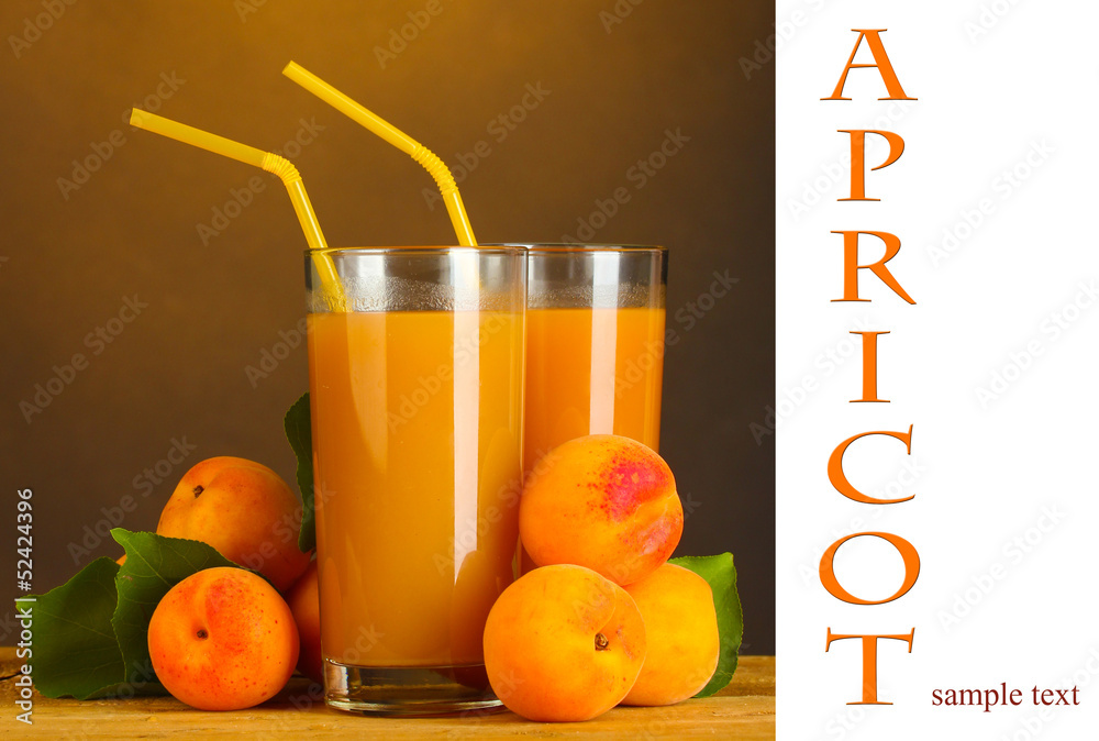 Glasses of apricot juice on wooden table on brown background Glasses of apricot juice on wooden table on brown background