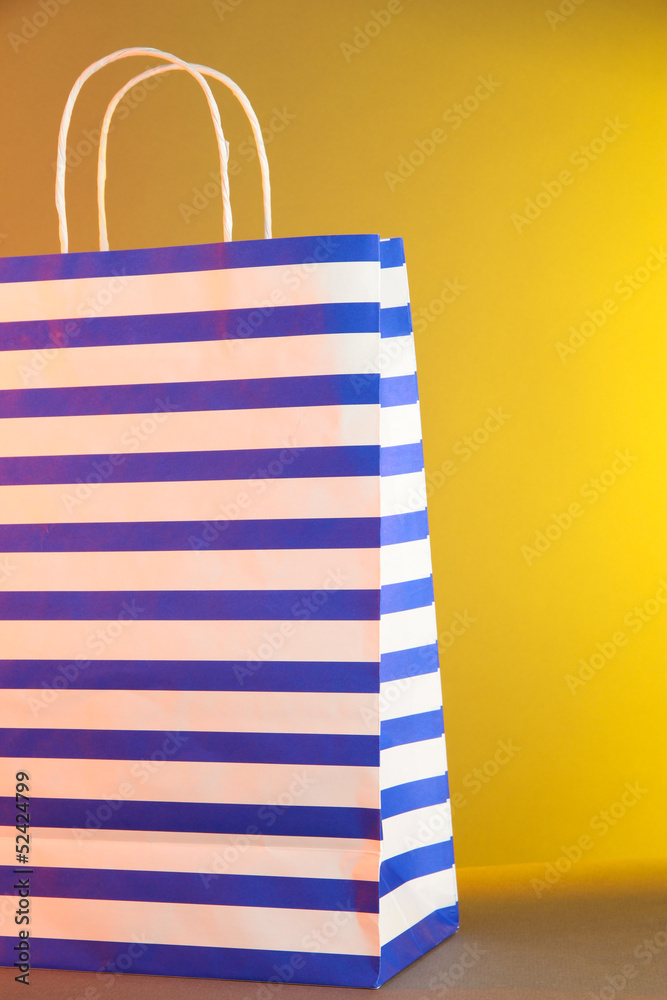 Fototapeta premium Striped bag on yellow background