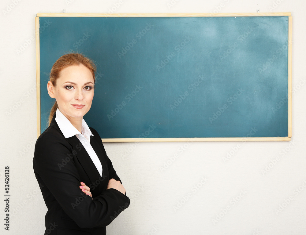 Portrait of teacher woman near chalkboard in classroom Portrait of teacher woman near chalkboard in classroom