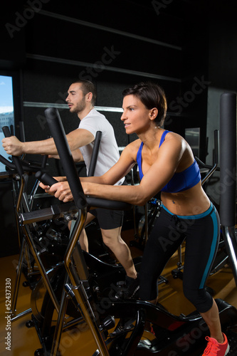 elliptical walker trainer man and woman at black gym