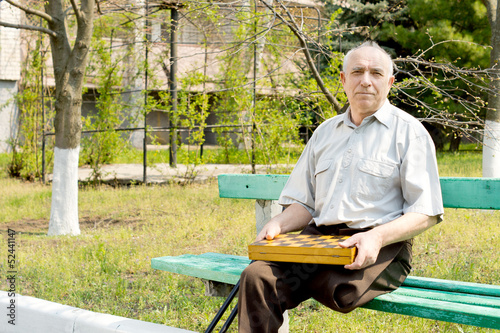 Obraz na płótnie Senior amputee sitting on a park bench w salonie
